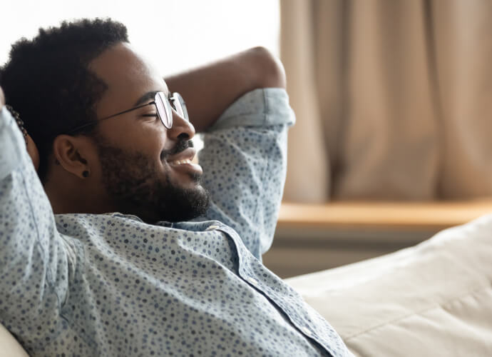 Smilende mand sidder på en sofa